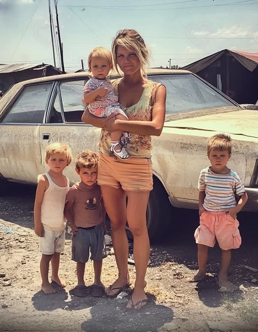 Mother of Four Lets Old Man Soaked in Rain into Her Home, Next Day She Sells Her House for $1 === A poor, widowed mother of four offered a drenched old stranger shelter to wait out the rain. The next day, she sold the only house she had for just $1 and decided never to return to that house again. Angelina Gibson, 34, sat by her window, staring at the rainy afternoon that ruined her day. She sold flowers and eggs on the street daily, and with the scant amount she made, she would buy groceries to feed her four children. Three years ago, Angelina’s husband, Mark, died a month after their fourth son, Robin, was born. The poor woman found no good job due to being illiterate, but she managed as much as possible. Her only source of income was hit hard that day because of the heavy showers. Angelina pressed her teary eyes on the window pane and looked outside. She wished for bright weather, but it started to rain more heavily than before. Then she noticed an older man, soaking wet, waiting on the farther end of the street… “Oh, that poor old man. What is he doing there? He’s drenched,” she thought, and watched for a while. The man seemed fragile and couldn’t walk for long. He stood under a closed shop’s shutter, but the fierce showers soaked him wet. “Why are you looking at me like that?” she asked him, putting on a tattered sweater to cover up. Angelina felt sorry for the older man. He was well-dressed and looked rich. “But why is he walking on the street if he’s rich? Does he not have a car like all rich men do?” she wondered. Unable to bear it further, Angelina grabbed an old umbrella and rushed outside to the man. “My house is nearby. You can wait there until it stops raining if you don’t mind,” she said, offering the stranger shelter to wait out the rain. The older man was bewildered by the woman’s strange offer of help. He smirked and walked with her, although he was still baffled by why she offered him temporary shelter. “Um…Is this your house?” the old man said, grinning. “By the way, I’m Joe Tyler…nice to meet you, Ms…?” “Angelina Gibson!” the woman said as she dusted a makeshift chair made from old tires. “Please have a seat.” Joe looked around the house and saw Angelina’s four children sleeping on the floor. “Why are your children sleeping?” Angelina told him they were hungry and hadn’t eaten anything for lunch. “I’m sure God will help me feed them a good dinner. But it should stop raining first.” Joe was astonished by the woman’s confidence. He noticed Angelina’s house was too compact for a family of five, and the condition of the house bothered him. It did not have any appealing furniture, and their old TV was broken, with cobwebs visible around it. At first glance, Joe surmised that the woman had been struggling with their living conditions. After moments of silence and deep thought, Joe asked Angelina to move in with him, much to her astonishment. “What? I don’t get you, Mr. Tyler. Did I just hear you ask me to move in with you?” she asked him. “Why would you want me to do that? And what’s wrong? Why are you staring at me?” She looked at the old stranger, and for a second, she felt she had done something wrong in offering him shelter. “Why are you looking at me like that?” she asked him, putting on a tattered sweater to cover up….(continue reading in the 1st comment